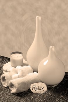 relaxing sepia spa arrangement with candle and washcloths