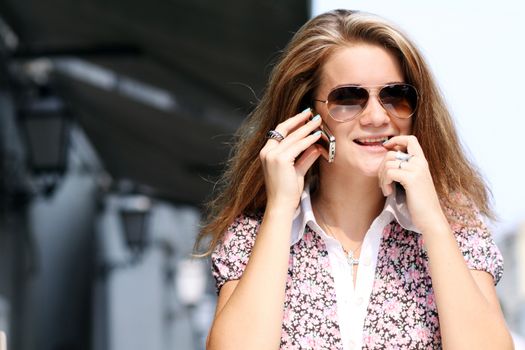 Happy young lady talking on mobile phone