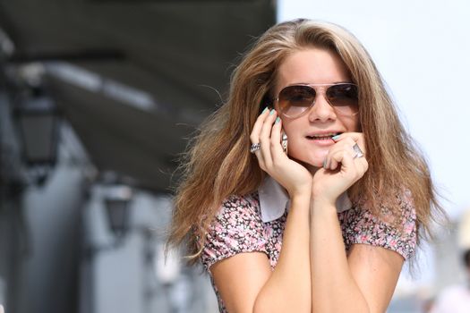 Happy young lady talking on mobile phone