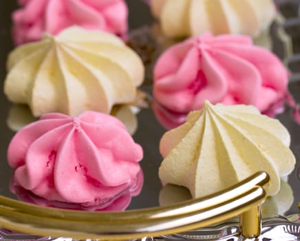 Yellow and pink meringues on a tray