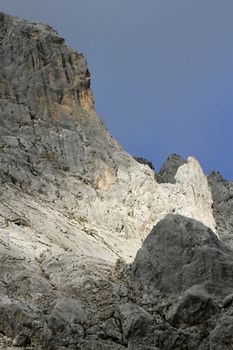 Beautiful sunlight on grey Alps rock by cloudy weather