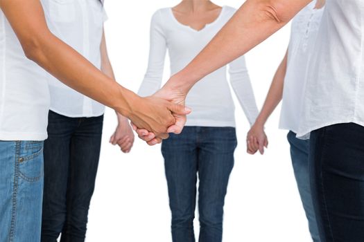 Women standing and holding hands in a circle on white background