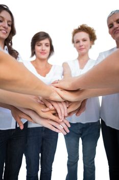 Relaxed models joining hands in a circle on white background
