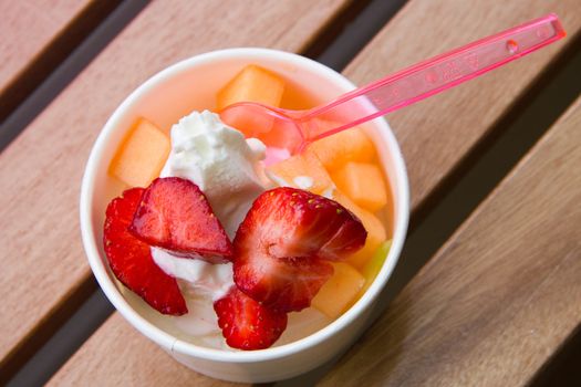 Delicious ice cream with strawberry and melon topping