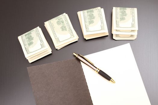 Lots of dollars with an open copybook
