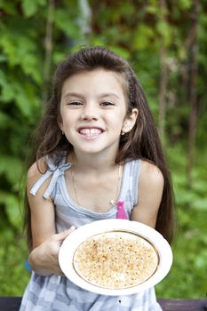 little girl holding a plate with a white currants