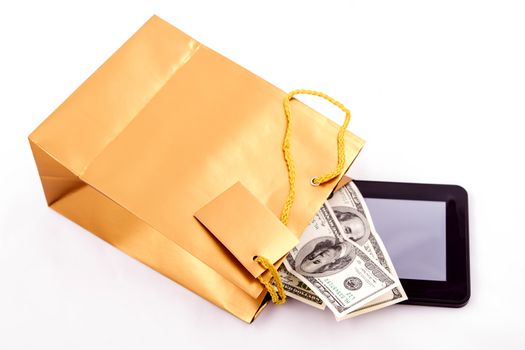 A gold gift bag with a Tablet PC and dollars isolated
