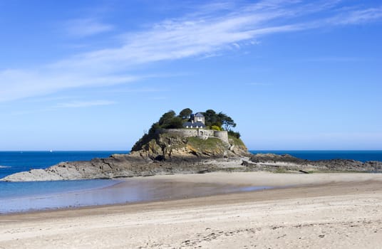 Landscape, seascape with beach and a house on top of a rock.