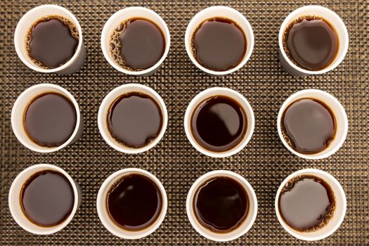 Lots of disposable cups with coffee 
