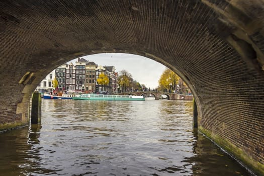 View from under bridge to Amsterdam  in the late autumn, Amstel river