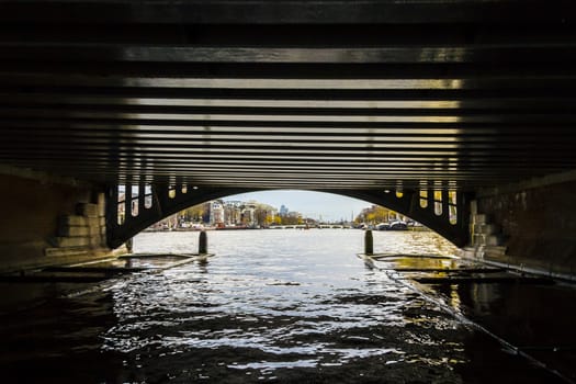 View from under bridge to Amsterdam  in the late autumn, Amstel river