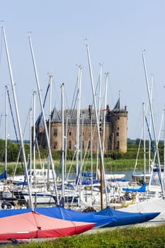 view of the castle Muiderslot through the masts of yachts