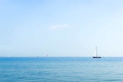 Seascape with sailboat the background of the blue sky.