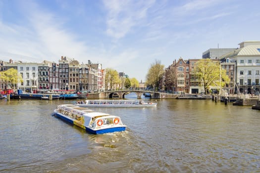 View on the houseboats with cruiseboat in Amsterdam the Netherlands