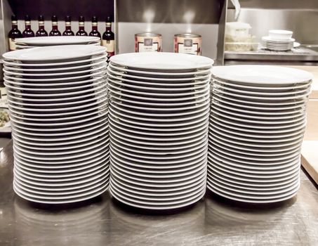 Stacks of white plates against a restaurant background