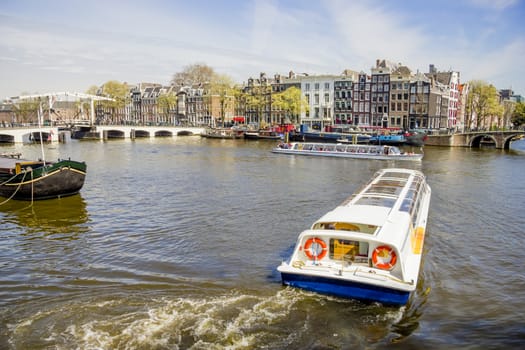 View on the houseboats with cruiseboat in Amsterdam the Netherlands