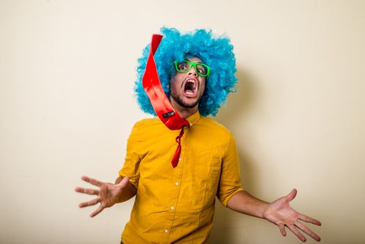 crazy funny young man with blue wig on white background