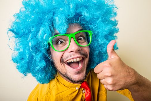 crazy funny young man with blue wig on white background