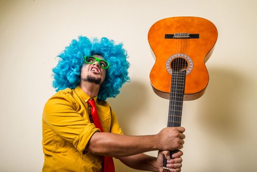 crazy funny young man with blue wig on white background