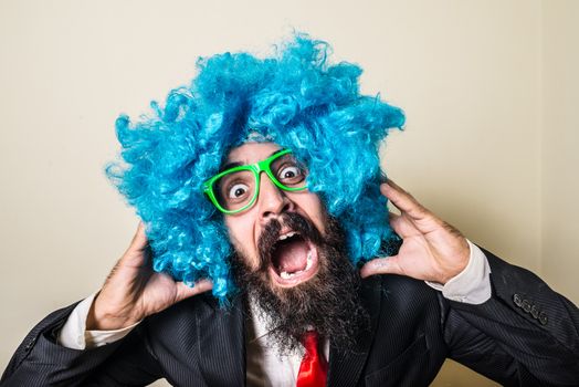 crazy funny bearded man with blue wig on white background