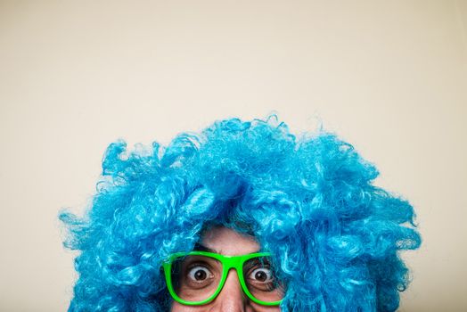 crazy funny bearded man with blue wig on white background