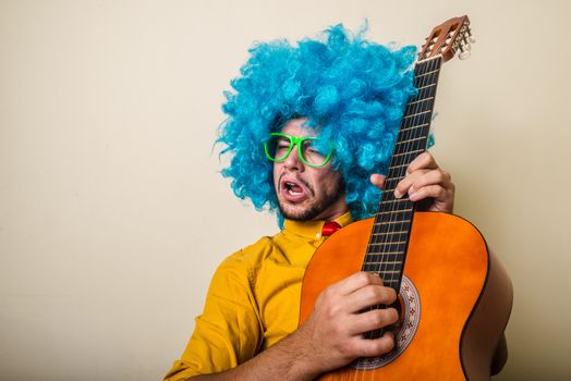 crazy funny young man with blue wig on white background