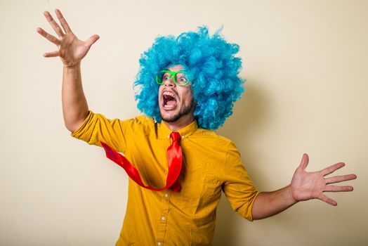 crazy funny young man with blue wig on white background