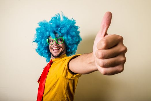 crazy funny young man with blue wig on white background