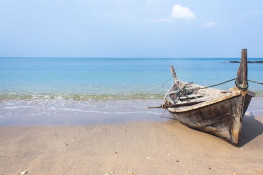 Long tail boat by the beach with blue sea and sky