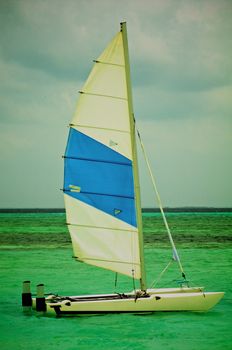 Small Sailboat in Ocean Lagoon near Beach 