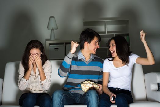 group of young people watching TV on the couch, sports fans