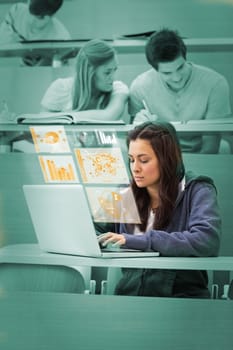 Pretty brunette studying on her digital computer in lecture hall