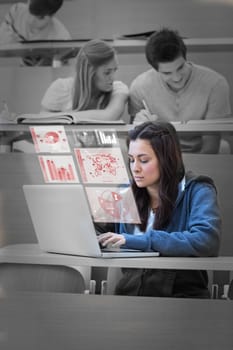 Pretty brunette studying on her futuristic laptop in lecture hall