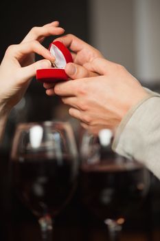 Close up on a woman taking the ring during marriage proposal in a classy restaurant