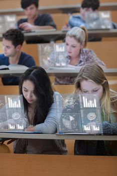 Concentrated students working on their digital tools in lecture hall