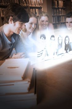 Smiling college friends watching photos on futuristic interface in university library