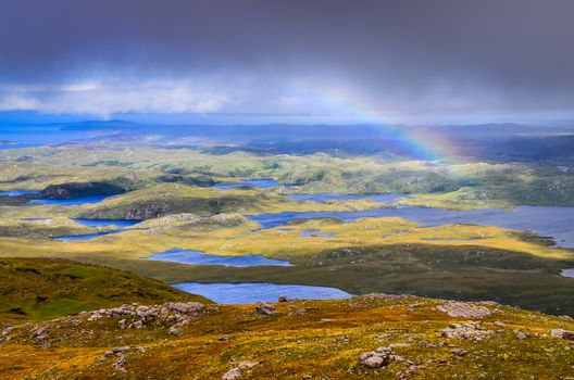 Scenic view of beautiful lakes, clouds and rainbow in Inverpolly area, highlands of Scotland, United Kingdom
