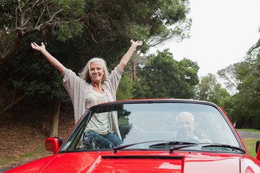 Mature couple having a ride together in red convertible