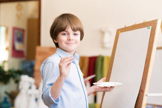 portrait of a boy standing next to his easel, a drawing lesson