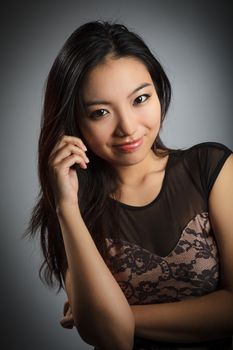 Attractive asian girl in her twenties isolated on a plein background shot in a studio