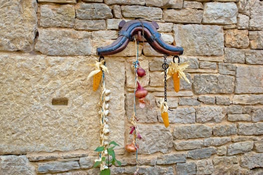 Traditional Dalmatian ornament on stone wall - corn, onion, garlic, horse collar