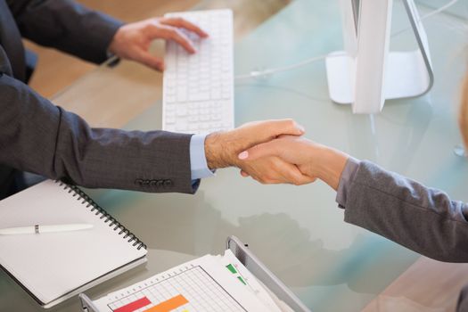 A handshake between business people in an office