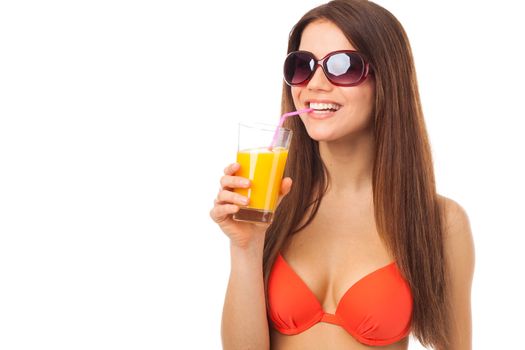 Smiling woman with sunglasses drinks orange juice in summer, isolated on white