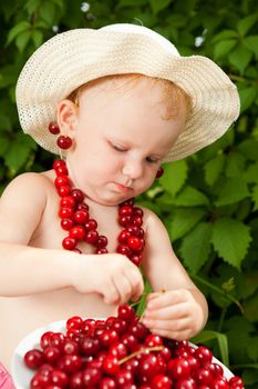 small child with cherries outdoors