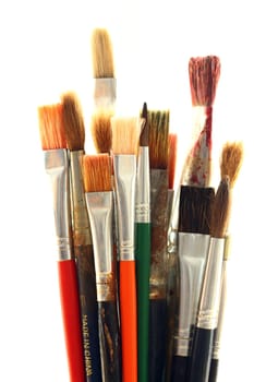Old and used colorful paintbrushes over white