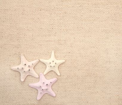 Background with starfishes on canvas texture