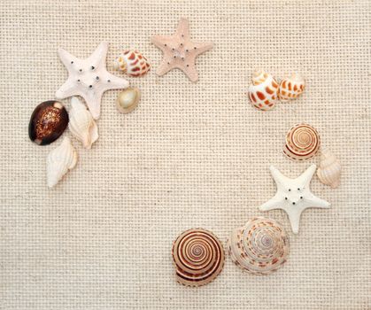 Background with starfishes and conches on canvas texture