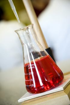 Red liquid inside a glass flask in science lab