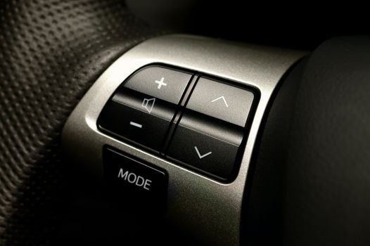 Audio control buttons on the steering wheel of a modern car