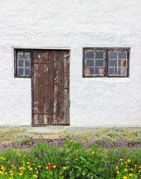 Facade of a rustic house, with garden in front of it. Gotland, Sweden.